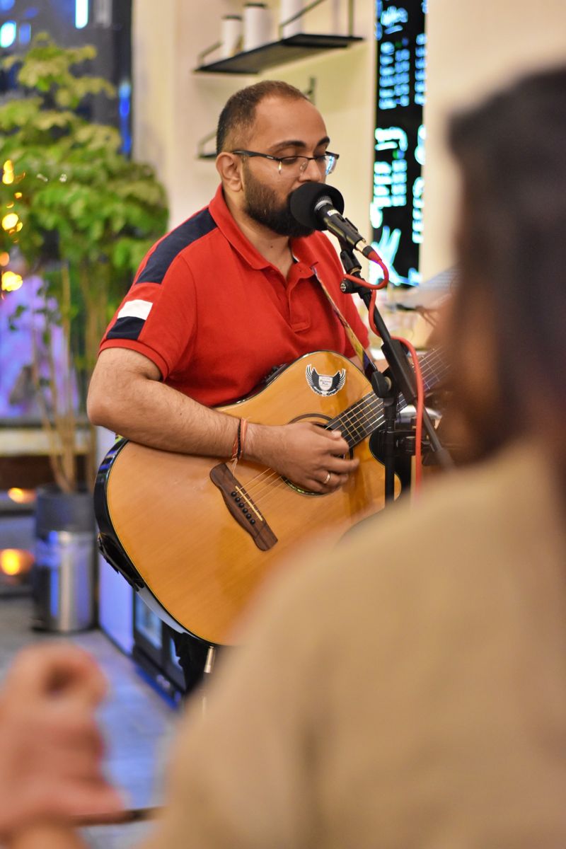 A musician playing guitar at a Calm Cup music evening